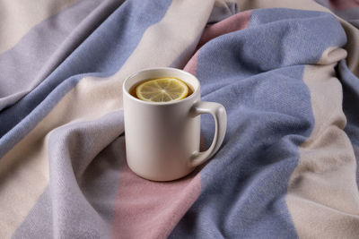 High angle view of coffee cup on bed