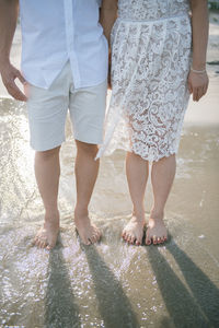 Low section of women walking in water