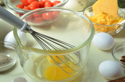 Egg yolks, whisk in glass mixing bowl, cheddar cheese, black pepper, ingredients for  quiche