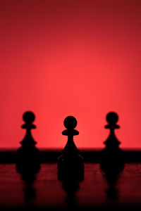 Silhouette people on red water against sky at sunset