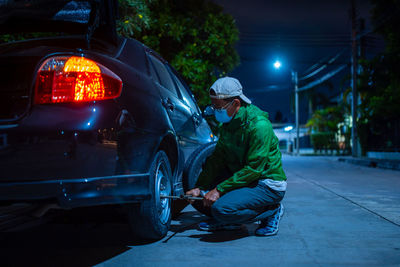 Man sitting on street at night