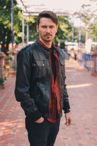 Portrait of man standing on footpath