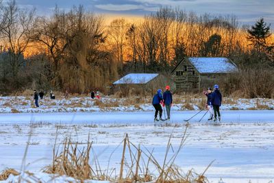 People playing hockey on snow covered field