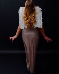 Rear view of woman against black background