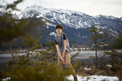 Young woman standing on snow against mountains