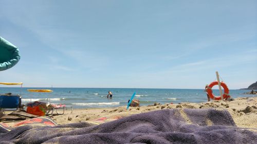 Blanket at beach against sky