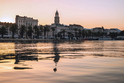 Reflection of buildings in city at sunset