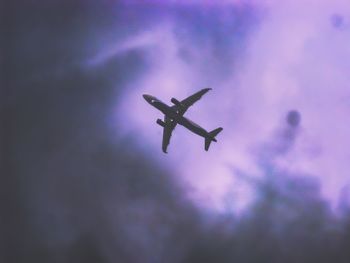 Low angle view of airplane flying against sky