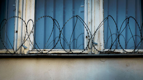 Close-up of barbed wire and wall