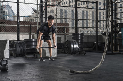 Man training at rooftop gym in bangkok