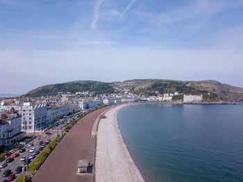 High angle view of city by sea against sky