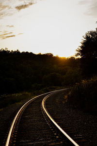 View of railroad tracks by road against sky