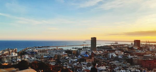 High angle view of townscape by sea against sky