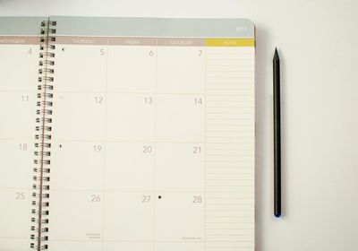 Close-up of pencil by calendar on table
