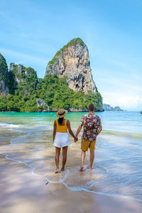 Rear view of woman standing at beach