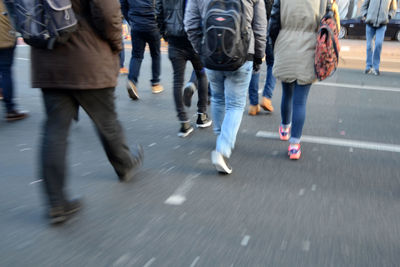 Low section of people walking on city street