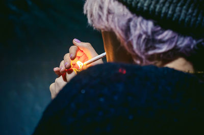 Close-up of young woman lighting cigarette