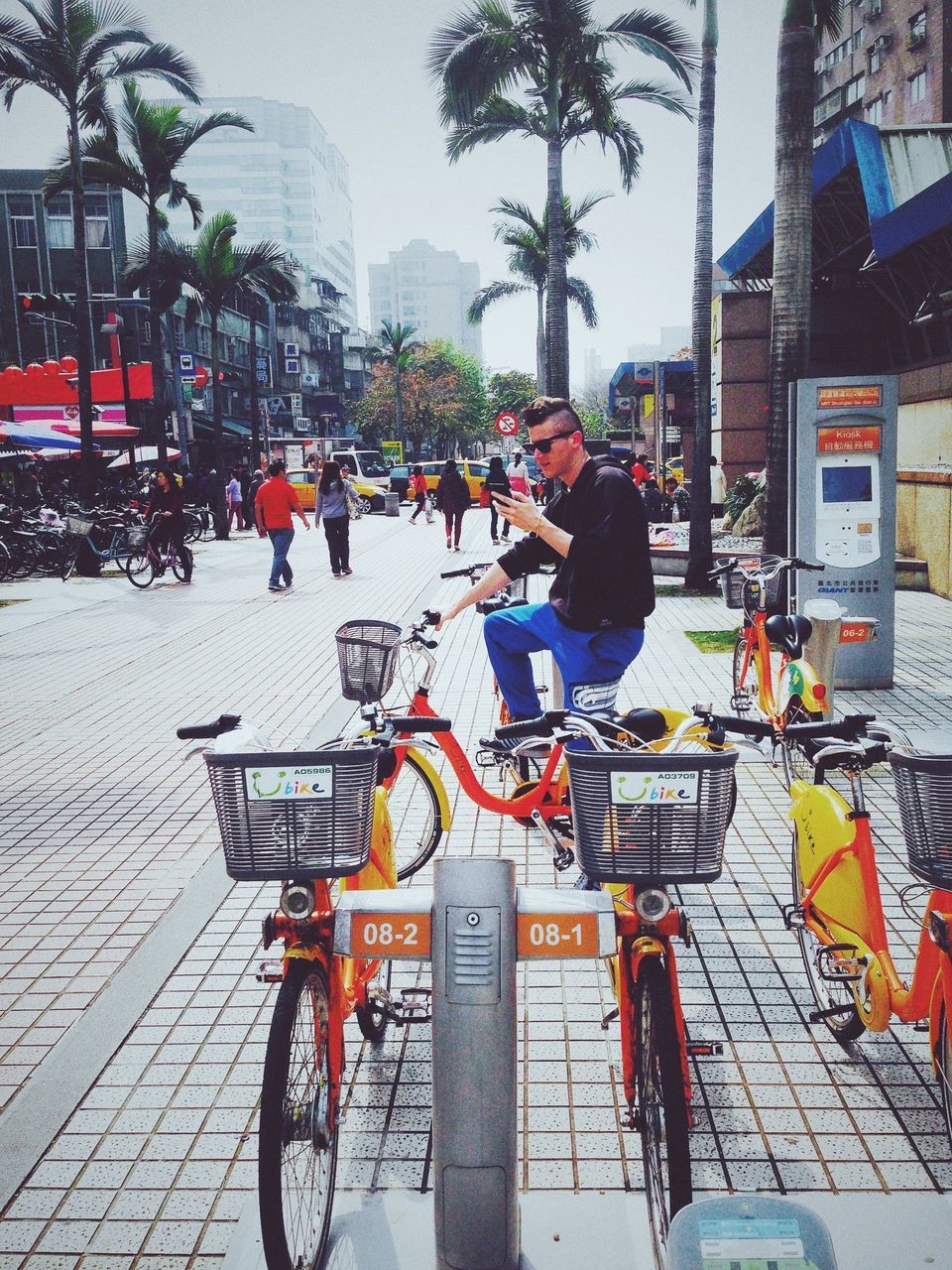 building exterior, street, city, architecture, built structure, men, transportation, land vehicle, lifestyles, city life, person, bicycle, mode of transport, walking, sidewalk, city street, leisure activity, road, day