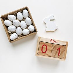 High angle view of eggs and calendar on white background