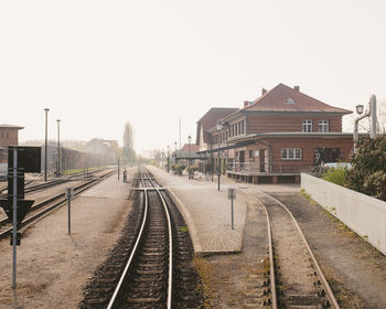 Railroad tracks amidst buildings against clear sky