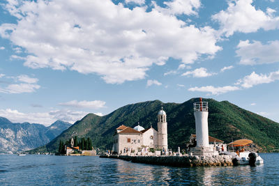 Buildings by sea against sky