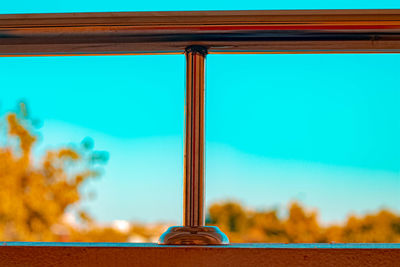 Close-up of glass on table against blue sky