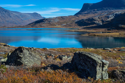 Scenic view of calm lake against rocky mountains