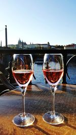 Close-up of wine glasses on table against clear sky