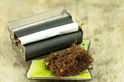 Close-up of marijuana with roller on table