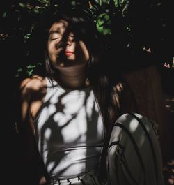 Young woman relaxing under tree