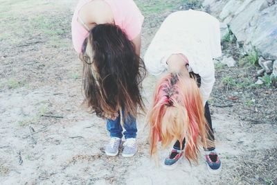 High angle view of female friends bending while standing on field