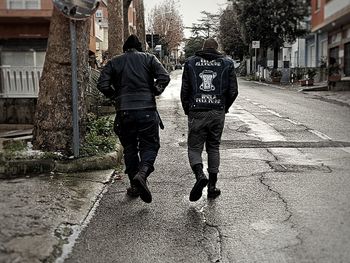 Rear view of men walking on street