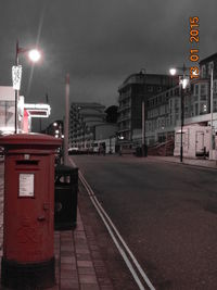 Illuminated street light in city at night