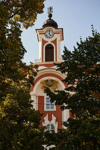 Low angle view of clock tower amidst buildings against sky