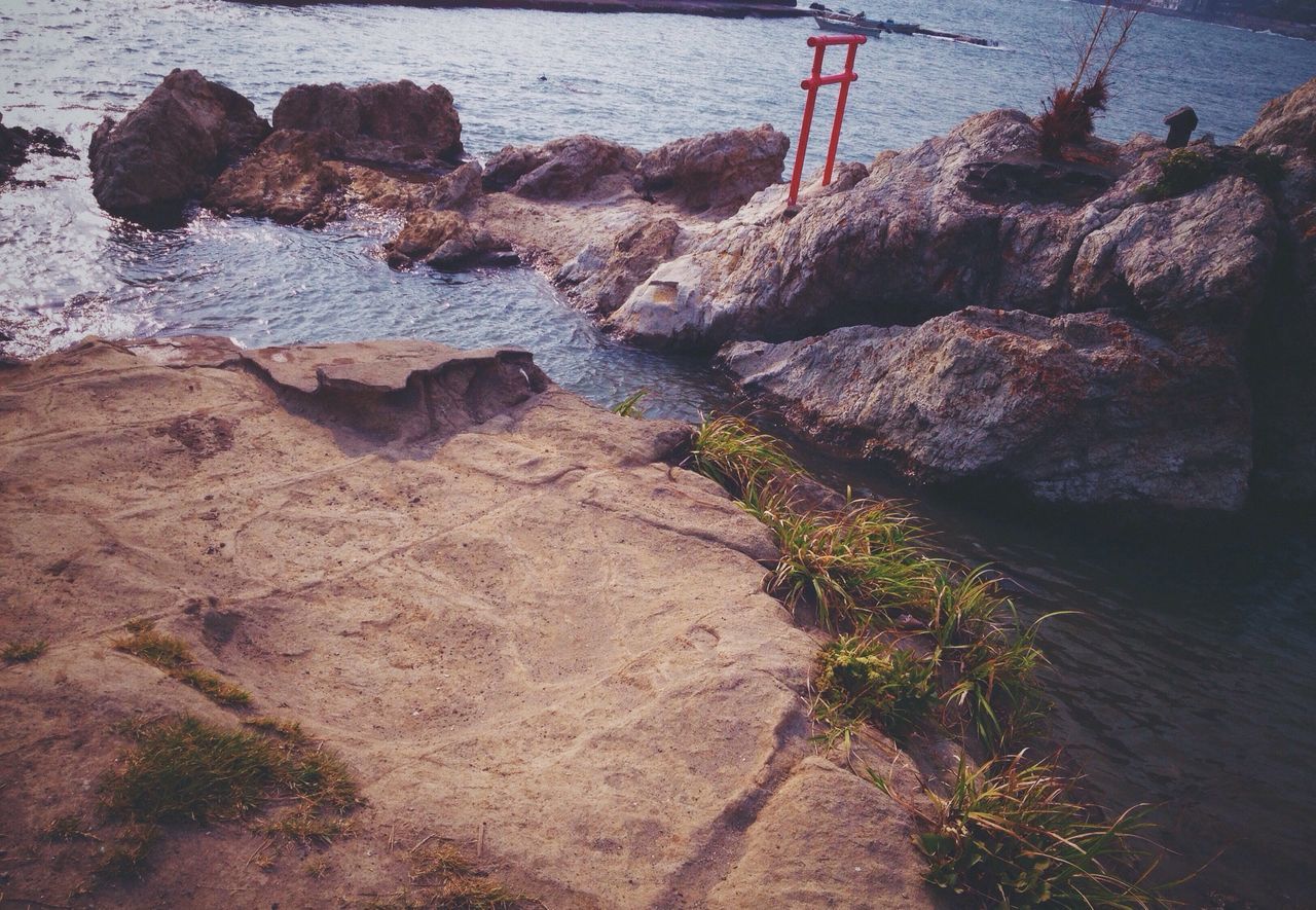 rock - object, beach, tranquility, rock formation, water, high angle view, nature, shore, rock, sunlight, sand, outdoors, tranquil scene, day, sea, no people, shadow, beauty in nature, scenics, non-urban scene