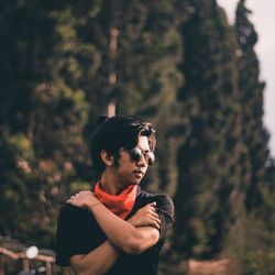 Young man looking away in forest