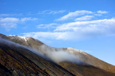 Scenic view of mountains against blue sky