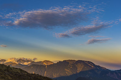 Scenic view of snowcapped mountains against sky during sunset