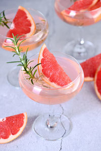 Goblet of sparkling wine with a slice of grapefruit and a sprig of rosemary