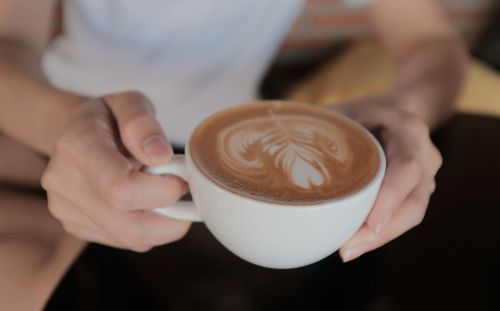 Cropped image of hand holding coffee cup