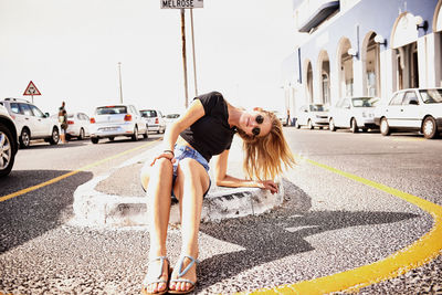 Portrait of woman with head cocked sitting on street