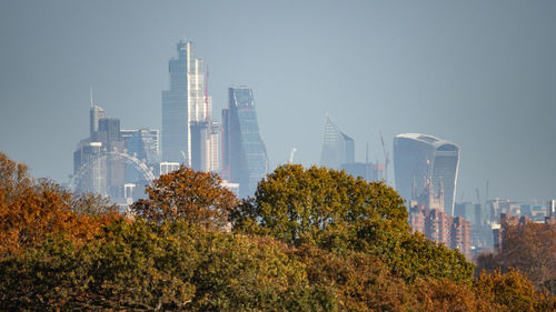 Panoramic view of trees and buildings against sky