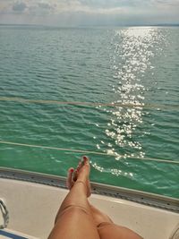 Low section of woman on sea against sky