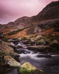 Scenic view of river amidst mountains against sky