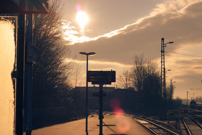 Signboard at railroad station platform against sky