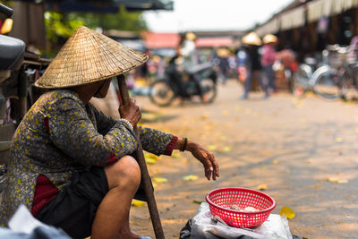 Side view of woman selling fruits at street market