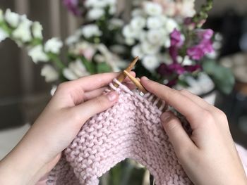 Cropped hands of person knitting at home