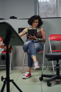 Young woman using phone while sitting on seat