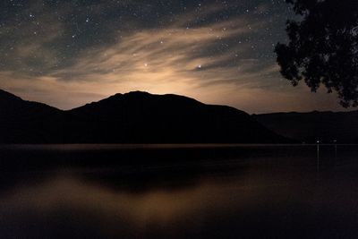 Scenic view of lake against sky at night