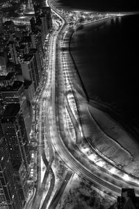 High angle view of illuminated street amidst buildings at night